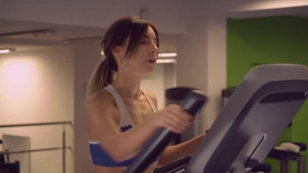 Femme caucasienne s'entraîne sur la machine cardio . — Video