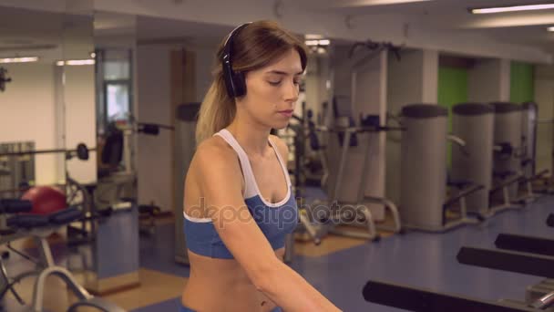 Sportive va sur les machines cardio écouter playlist via écouteurs  . — Video