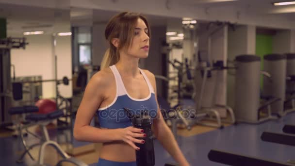 Sportvrouw gaande van cardio machines dranken speciale drank. — Stockvideo