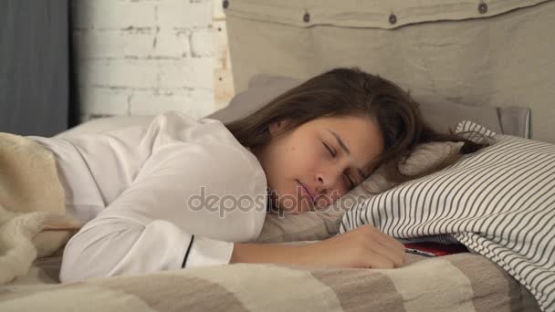 Fêmea deitada em travesseiros perto do telefone móvel . — Vídeo de Stock