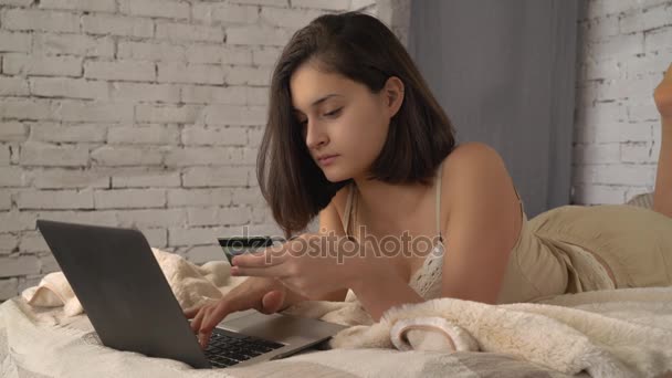 Девушка, глядя на экран ноутбука с улыбкой выбрать покупки сайт электронной коммерции — стоковое видео