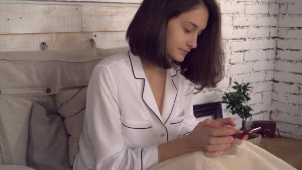 Sonriente uso femenino internet por teléfono en apartamento . — Vídeos de Stock