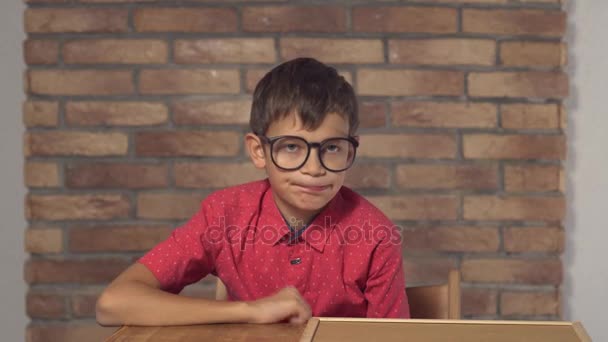 背景赤レンガの壁にレタリング販売フリップチャートを保持して机に座っている子 — ストック動画