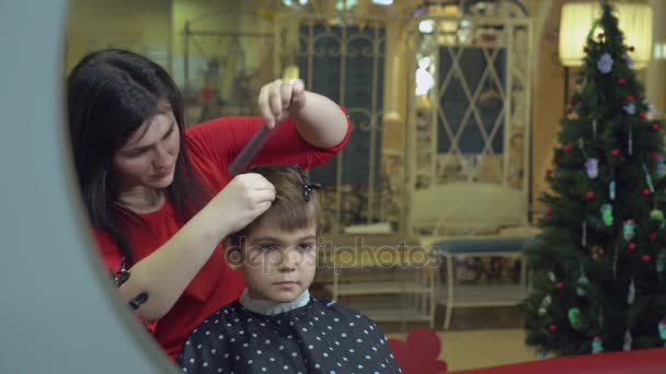 Barber with smiling kid in hairdressers parlor. — Stock Video