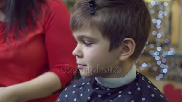 Cortador de pelo con niño en los peluqueros . — Vídeos de Stock