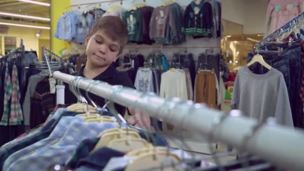Criança escolhe vestuário na loja . — Vídeo de Stock