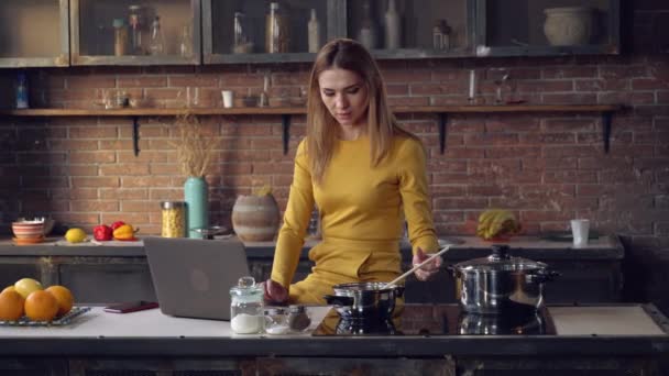 Sorrindo o computador de uso feminino e mexe o molho — Vídeo de Stock