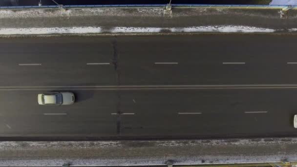 Antena - samochody jazdy na dwupasmowej drogi przez śnieżny krajobraz — Wideo stockowe