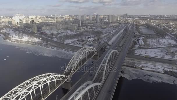 Пролетая над железнодорожным мостом и Трасской возле жилого массива, люди отправляются на работу в офис, на улицу зимой — стоковое видео