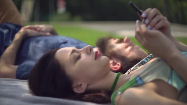 Ein junges Paar chillt im Park. — Stockvideo