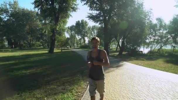 Facet jest jogging poza w parku. — Wideo stockowe