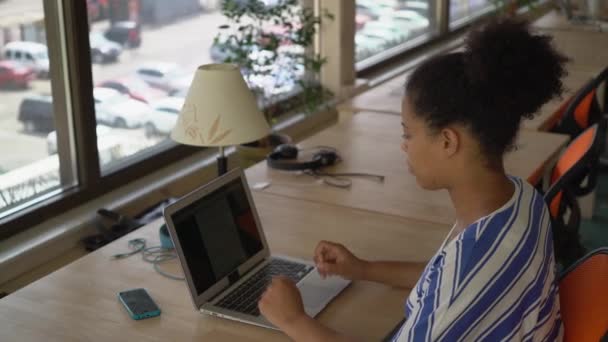 Kvinna mulatt arbetsplats med utsikt över gatan. — Stockvideo