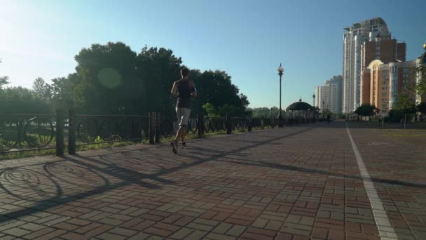 Un mec en forme fait du jogging dehors, vue de dos . — Video