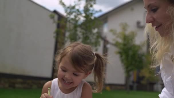 Feliz niño sonriente dibuja al aire libre . — Vídeo de stock