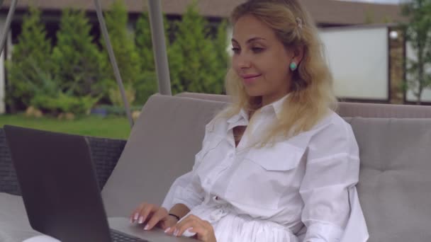 Caucasian lady scrolling on pc outdoors. — Stock Video
