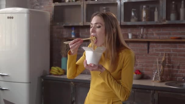 Fiatal nő élvezettel ázsiai ebéd fehér doboz. — Stock videók