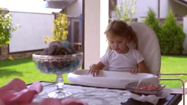 Κοριτσάκι να απολαύσετε το καλοκαίρι και γεύμα σε εξωτερικούς χώρους. — Αρχείο Βίντεο