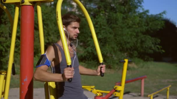 Un joven está haciendo ejercicio en el gimnasio del parque . — Vídeo de stock