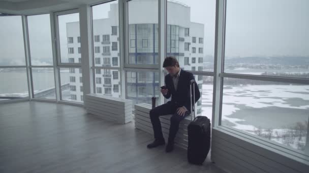 Мужчина с багажом с помощью мобильного телефона — стоковое видео