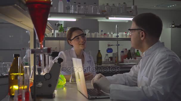 Dva šťastní lékaři hovoří v laboratoři. — Stock video