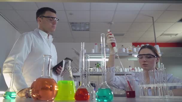 Dos científicos hombre y mujer en el laboratorio . — Vídeo de stock