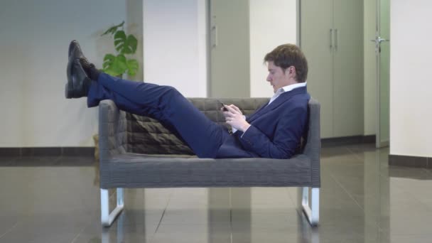 Guy leggen in Bank gekleed in jas — Stockvideo