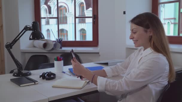 Mujer sosteniendo tableta sonriendo y saludando cliente . — Vídeos de Stock