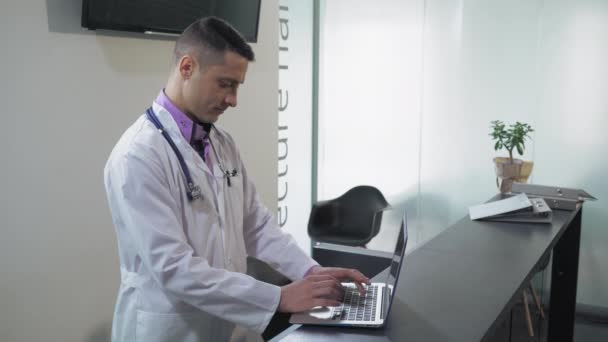 Porträt Arzt verwenden PC in Lobby-Klinik. — Stockvideo