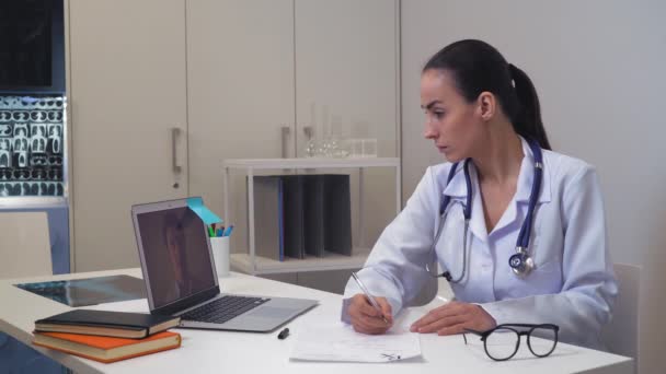 Vrouw arts praten met de man die het gebruik van app op computer. — Stockvideo