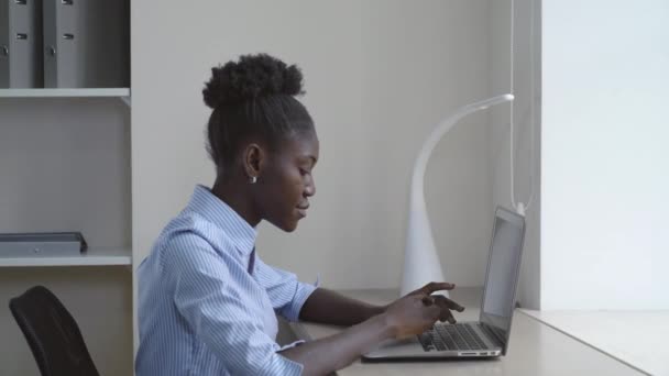 Afroamerikanerin arbeitet am Laptop. — Stockvideo