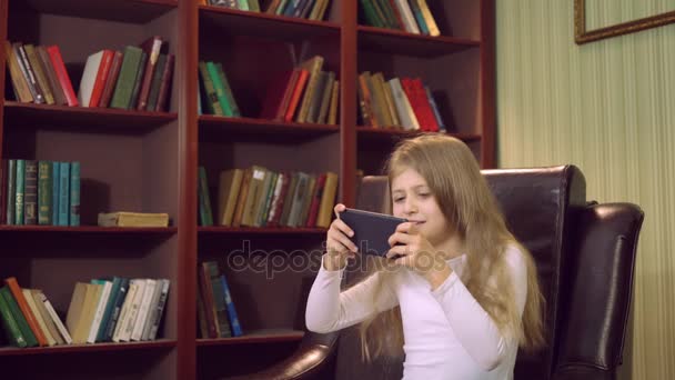 Κοριτσάκι με σύγχρονη συσκευή στο σπίτι — Αρχείο Βίντεο