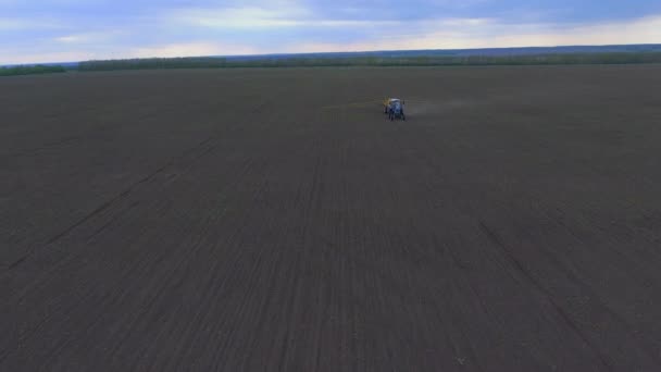 Tractor trata el campo, disparando desde el aire — Vídeos de Stock