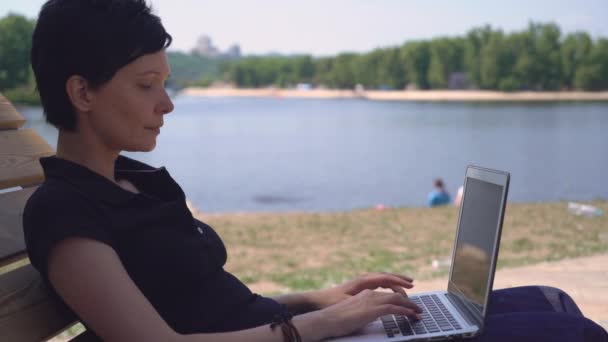Дама использует компьютер на открытом воздухе . — стоковое видео