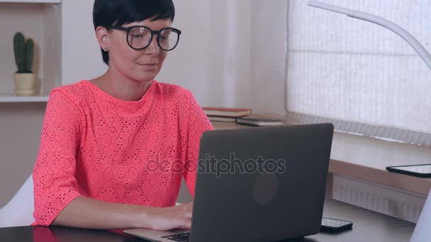 Mujer en el trabajo introduciendo datos en el ordenador portátil . — Vídeos de Stock