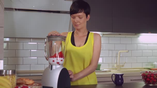 Девушка делает сок с ягодами в квартире . — стоковое видео