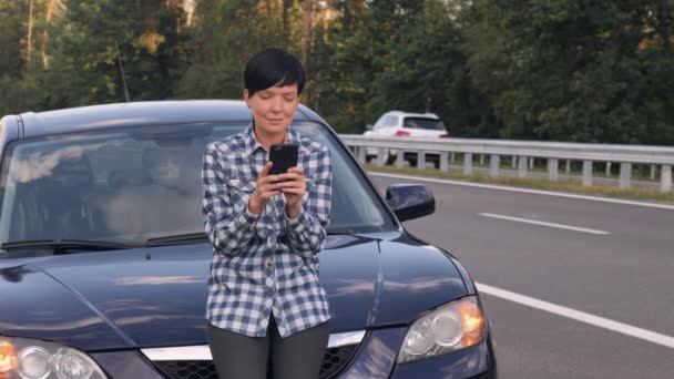 Girl messaging on cellular on the driveway. — Stock Video