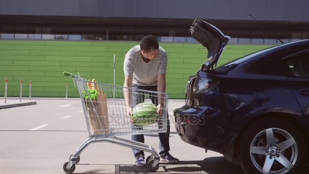 Homme avec chariot sur le parking du centre commercial . — Video