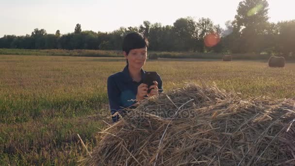 Kvinnliga agronomen har en paus användning smartphone för chatta. — Stockvideo