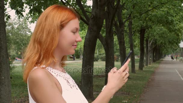 赤毛の女性の携帯電話上にテキスト メッセージ. — ストック動画