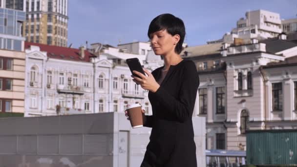 Attraente bruna in elegante abito uso mobile al di fuori . — Video Stock