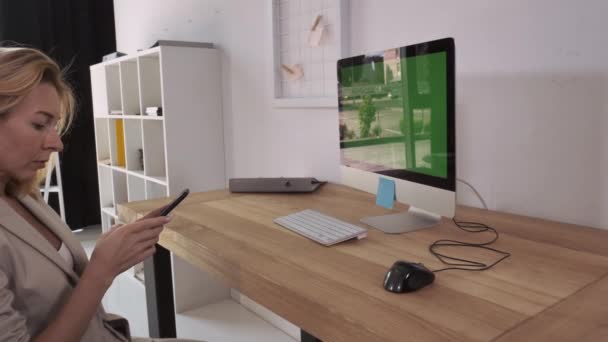 Volwassen vrouw met smartphone op het werk. — Stockvideo