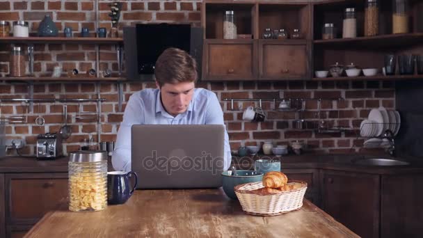 Jonge kerel lezen van nieuws op computer in de ochtend — Stockvideo