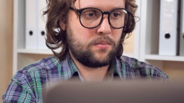 Hipster trabajando con portátil en el lugar de trabajo — Vídeo de stock