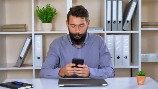Счастливый работодатель использует мобильный в рабочем пространстве — стоковое видео