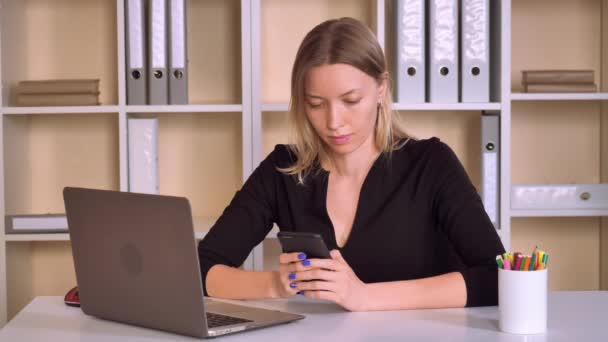 Schöne Arbeiterin mit blonden Haaren nutzt Smartphone — Stockvideo