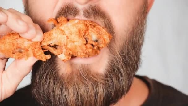 Erwachsene Männchen essen gebratene Hühnerkeulen — Stockvideo