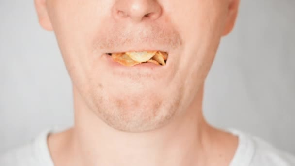 Cara inferior caucásico macho come patatas fritas — Vídeos de Stock