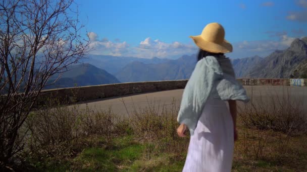 Chica trasera en sombrero mirando en paisaje de montaña — Vídeo de stock