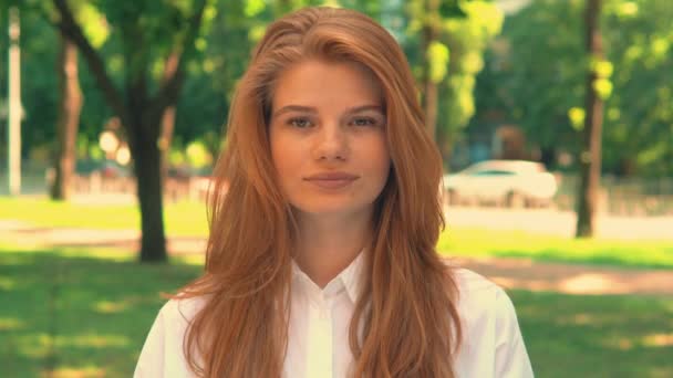 Retrato mujer joven con el pelo rojo posando al aire libre — Vídeo de stock