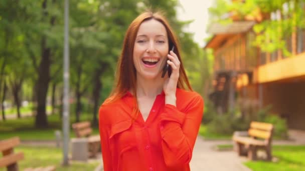 Primer plano una mujer de negocios pelirroja tiene una conversación por el móvil — Vídeos de Stock